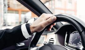 Person dressed smart holding steering wheel