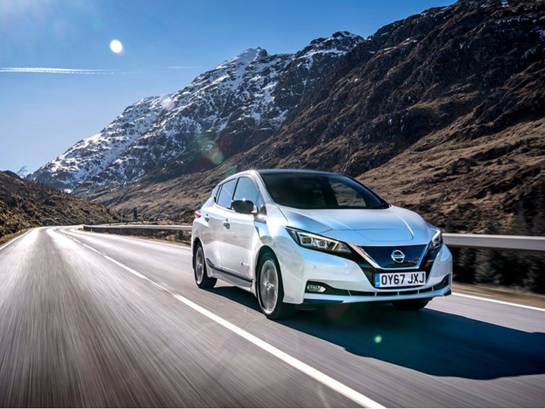 silver nissan leaf driving through mountain range