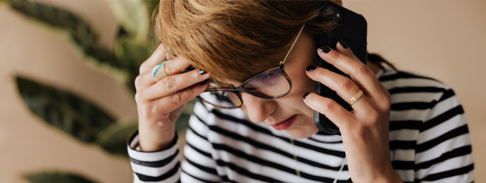 Anxious woman having phone conversation in office