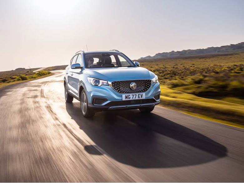 MG ZS EV driving on a road that snakes through grassland