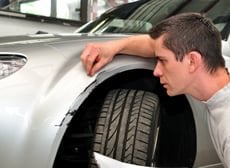 man inspecting car scratch