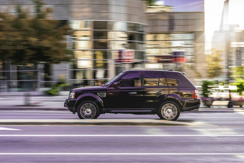 Black range rover driving in a city