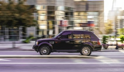 Black range rover driving in a city