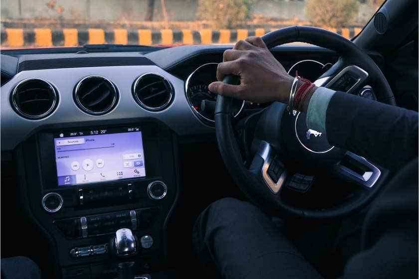 Person in a suit driving a nice car