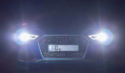 Audi car with headlights on in the dark