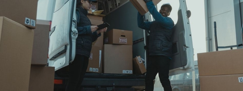 man and woman unloading boxes from a van