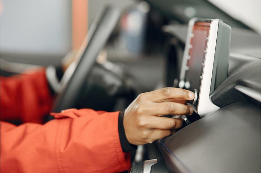 driver adjusting a dial on their infotainment system