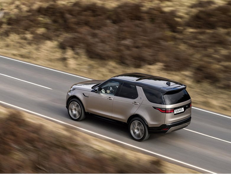 aerial shot of a range rover discovery driving on the road