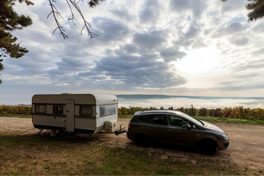 Car with a caravan attached with mountains in background