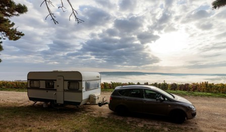 Car with a caravan attached with mountains in background