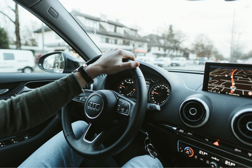 person driving Audi lease car with hand on the wheel