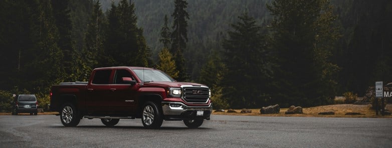 red chevrolet crew cab pickup truck on road during daytime