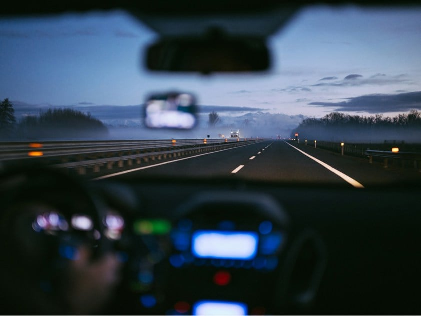 Person driving a car with with view of the road