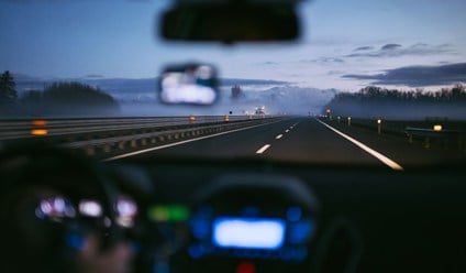 Person driving a car with with view of the road