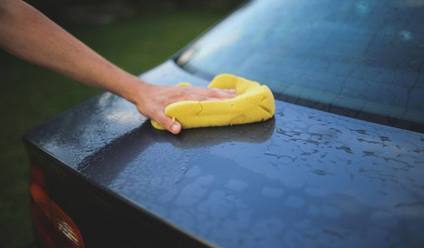 Person washing a car during a spring clean.