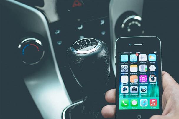 iphone being used by driver with gearstick in background 