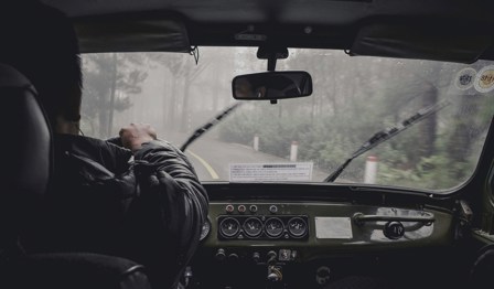 person driving car with windscreen wipers in use