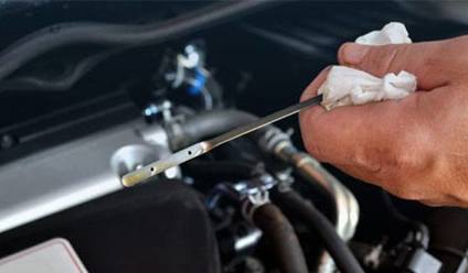 A mechanic working on a car engine in a repair shop.