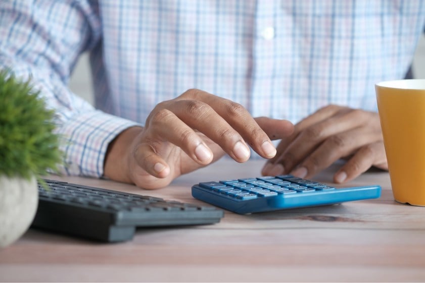 Person in smart workwear using blue calculator