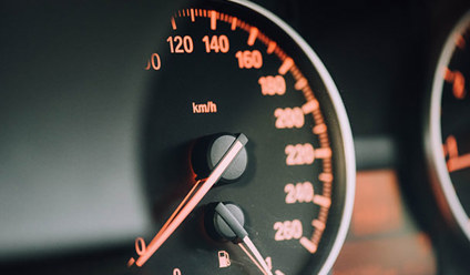 A close up of a car speedometer. 