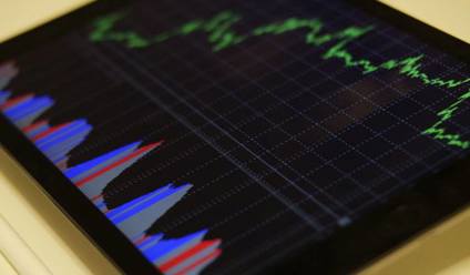 Close up of a tablet device showing stocks and shares graph. 