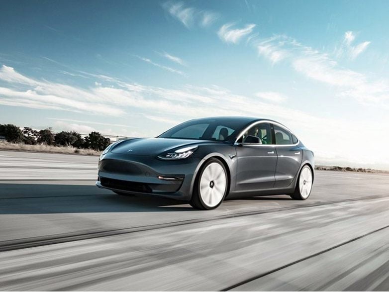 grey tesla model 3 driving fast