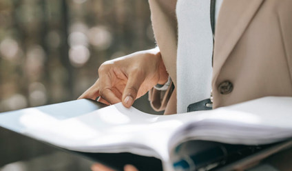 Person holding a binder full of documents