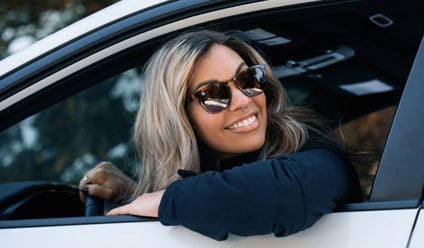 a woman sitting in the drivers seat of a car