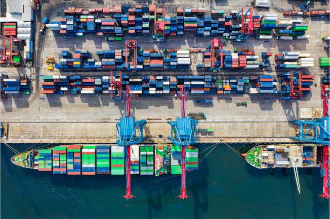 Merchant ship at a dock loading shipping containers