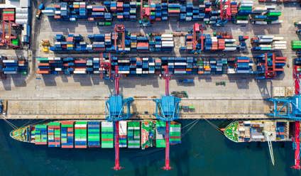 Merchant ship at a dock loading shipping containers