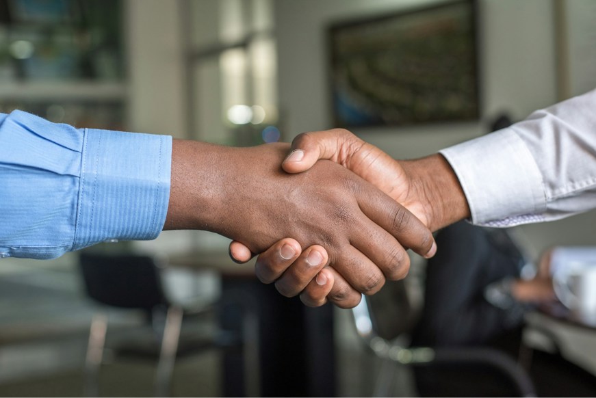 Two people shaking hands in business attire