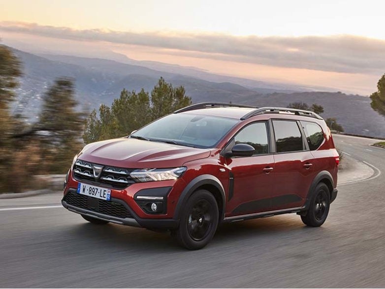 Red Dacia Jogger on a mountain road at sunset