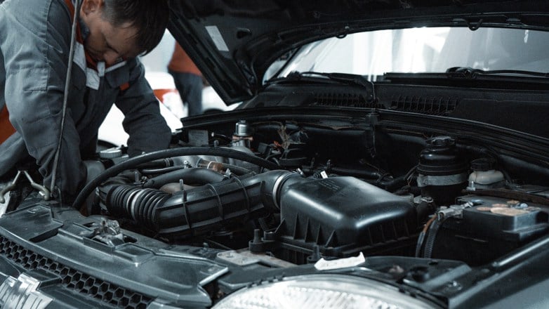 man servicing car